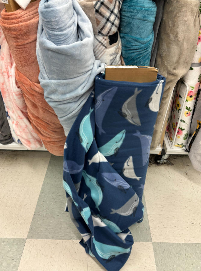 A roll of cartoon blue whale fleece fabric